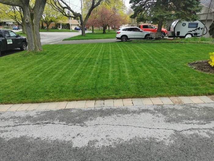 Striped lawn with the Zone Control truck at the curb